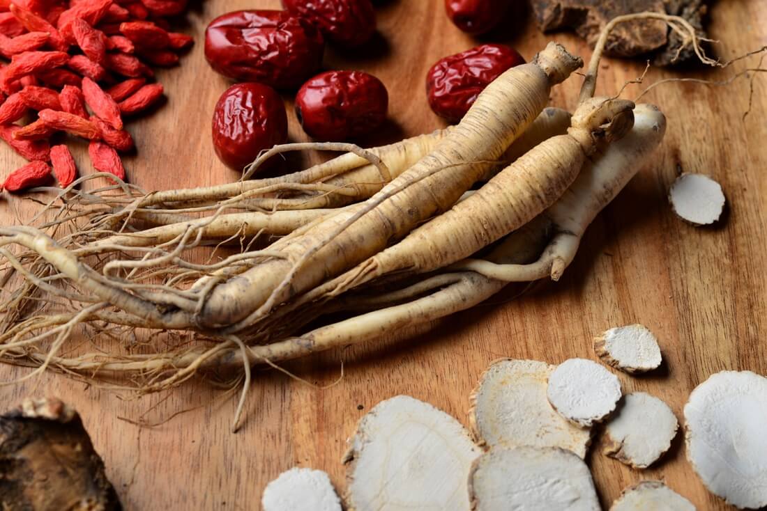 Korzeń żeń-szenia umieszczony na drewnianej tacce